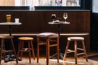 Stools with tables and benches at the Blue Maid, independent pub in Borough, South East London