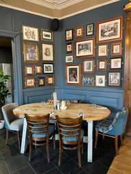 Chairs, table and frames on wall at the Duchess, independent pub in Hammersmith, West London
