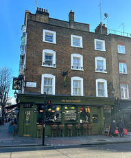 Brick and green facade at the Queen Charlotte, independent Soho pub in Fitzrovia, central London.