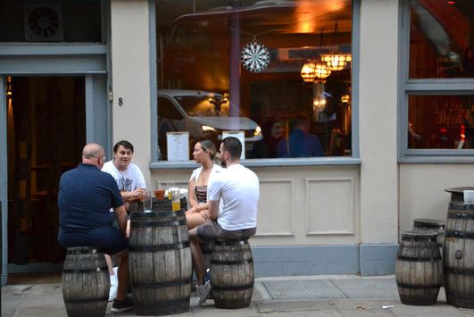 Customers on barrels at the terrasse at Old China Hand, independent Clerkenwell pub, London.