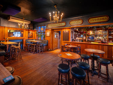 Bar, tables and stools with hanging lamps at the White Horse, independent pub in Peckham, South East London