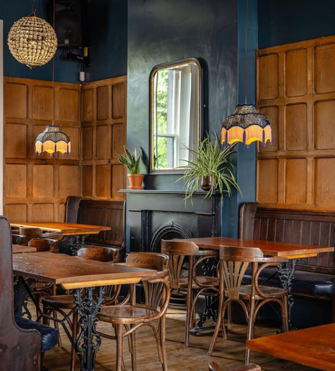 Tables, chairs, hanging lamps at the Earl of Derby, independent pub in Telegraph Hill, South East London