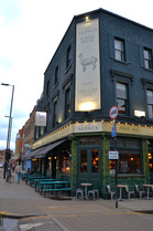 Terrasse with tables, benches and stoolsFacade with tables and benches at the Alpaca, independent pub in Islington, North London.