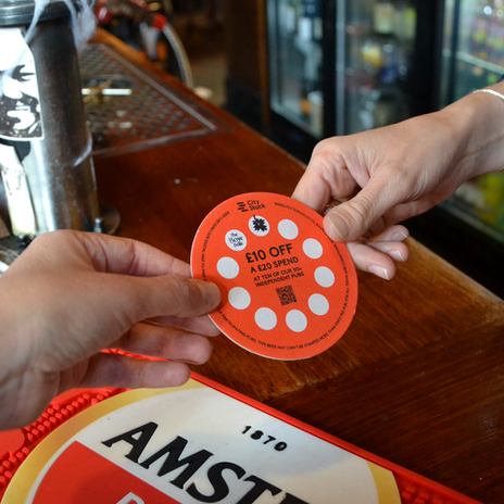 Special beer mat, pub voucher to get discounts at pubs. Giving it to the bartender.