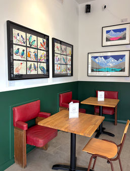 Cinema chairs, wooden tables and painting at the Hollydale, independent pub in Peckham, South East London.