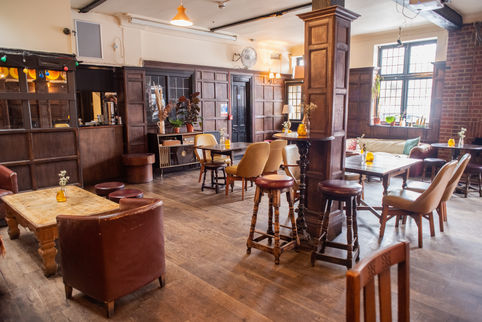 Tables, chairs, wooden floor at the Beehive, independent pub in Tottenham, North London.