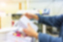 A person's hands wrapping a rubber band around a stack of printed letters for a direct mail campaign