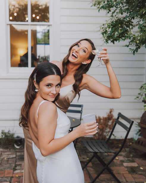 Bride and maid of honor celebrating with drinks at Austin Texas wedding