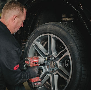 Mechanik przykręca koło do samochodu