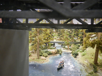 Canoe on river passing John's pine trees