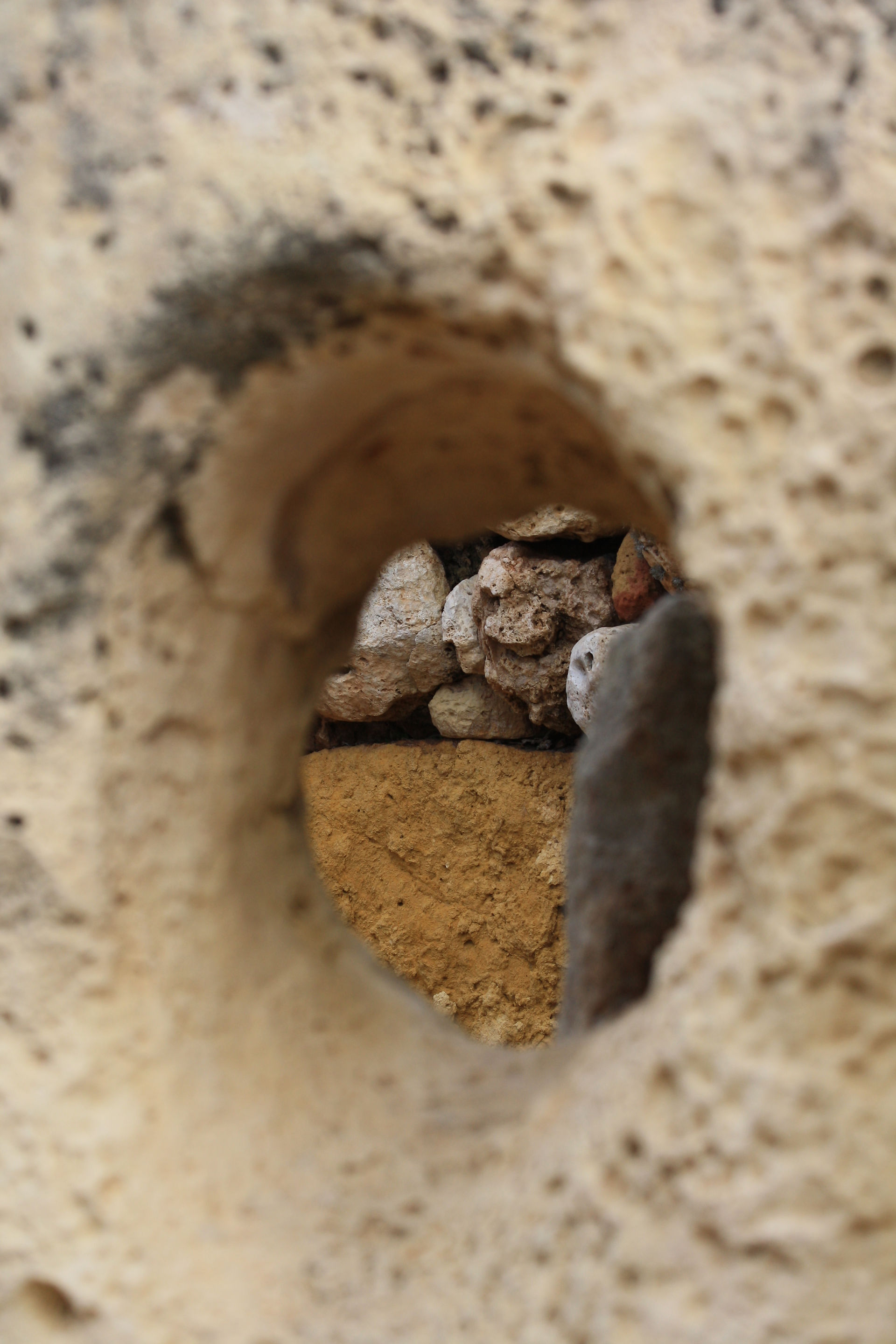 At the ruins of Santa Verna, looking through a worn hole from some tool into and inner room