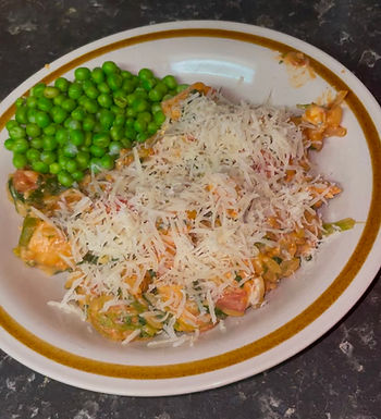 The creamy tomato chicken orzo dished up with peas on the side