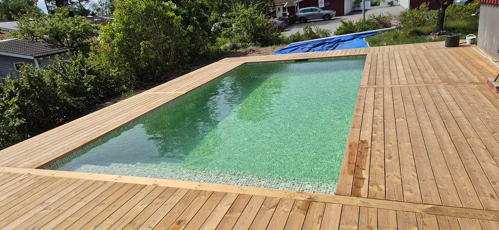 Nybyggd pool med trädeck runtomkring – modernt poolprojekt i Norrort av APK Entreprenad.