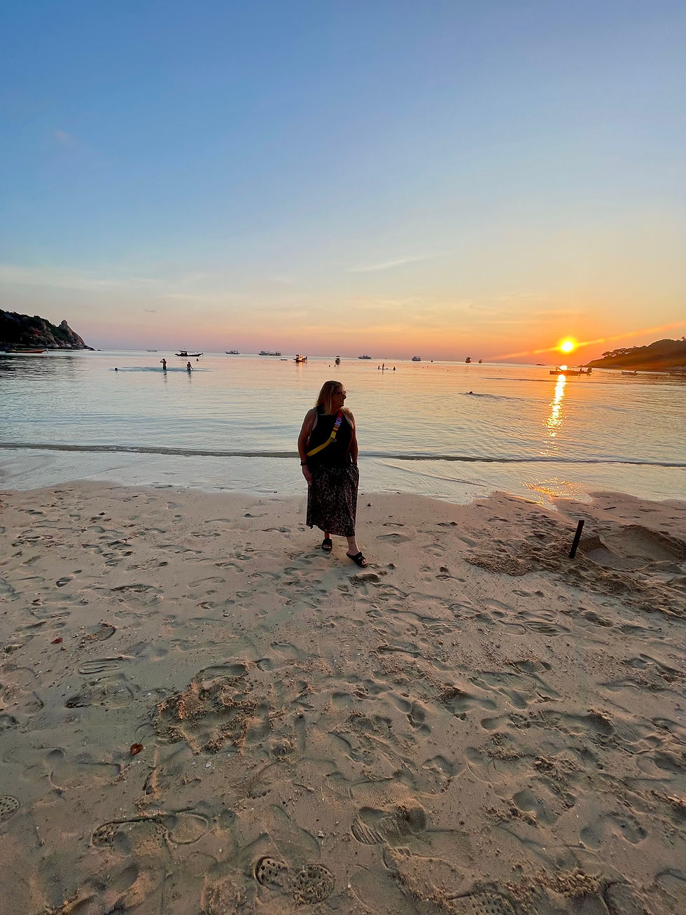 Woman walking along the shoreline in Koh Tao, Thailand during calm conditions.