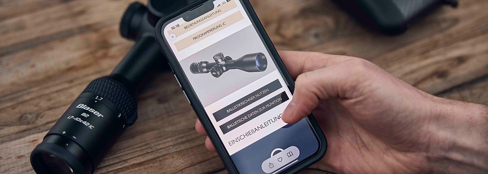 Hand with a smartphone showing a ballistic calculator app.