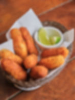Porção de bolinhos de bacalhau bem crocantes, servidos com limão (8 unidades)