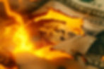 Burning US Dollar Bill symbolizing Extractive Economy and Economic Collapse