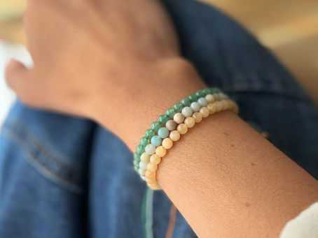 mano apoyada sobre la pierna que lleva varias pulseras de colores en la muñeca
