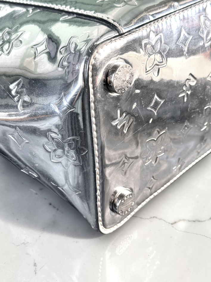 Bottom corner and silver-tone foot on Michael Kors mirrored tote