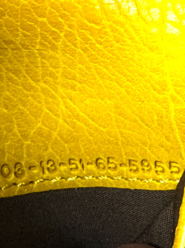 Close-up of Chloé logo stamped into the mustard yellow grained leather interior of the Paddington wallet.