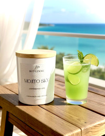 a candle with a cocktail by the water
