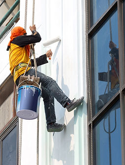 Painter painting exterior of commercial building – professional painting & decorating services UK