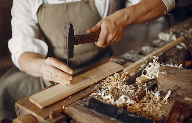 Artisan au travail dans son atelier de menuiserie, représentant la typologie de clients artisans accompagnés par RATIO