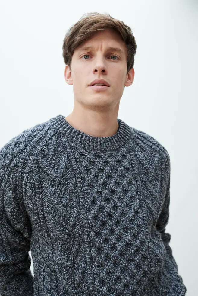 Mann in Aran Pullover in Charcoal
