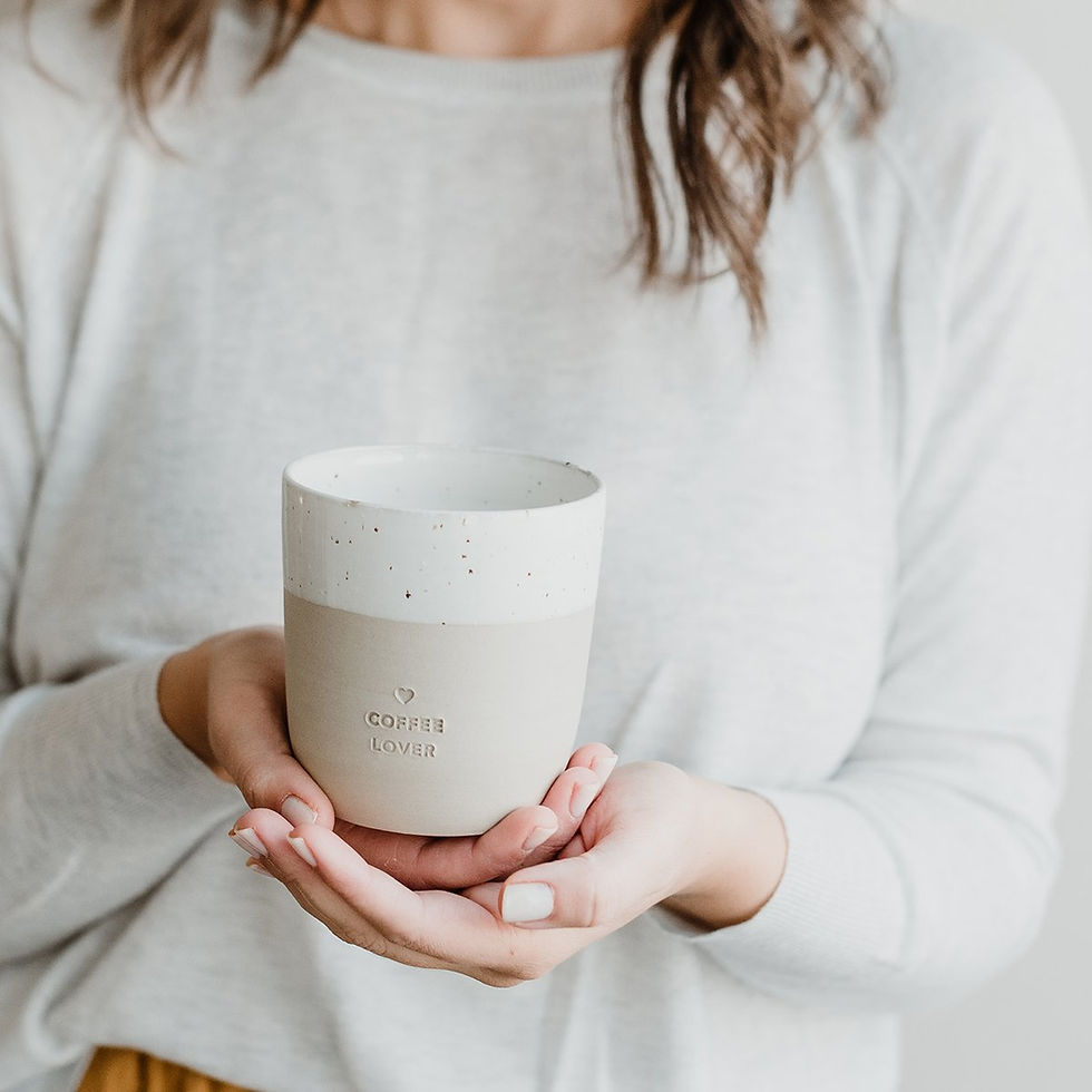 Frau hält Becher COFFEE LOVER vor sich in den Händen