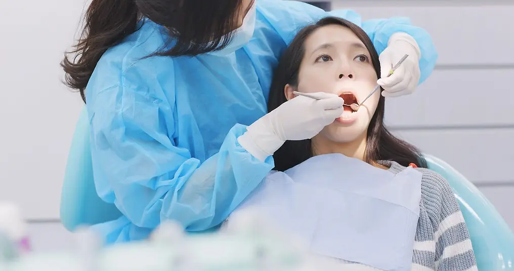 Asian-woman-getting-an-oral-exam-from-an-Emergency-dentist-Coral-Springs.webp