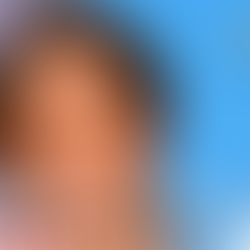 Victoria Beckham smiling brightly in a red top, showing her Hollywood smile transformation.