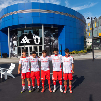 The five selected players stand arm-in-arm smiling in full FC Bayern Youth Cup uniforms in front of the Adidas headquarters in Portland, Oregon.