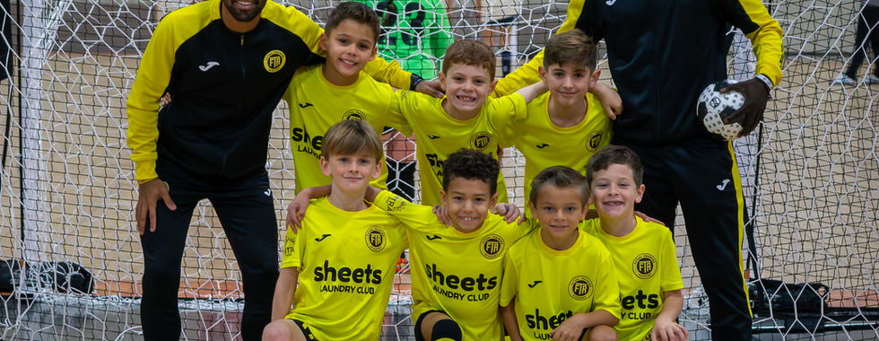 Youth futsal team and coaches wearing "Sheets" jerseys on court.