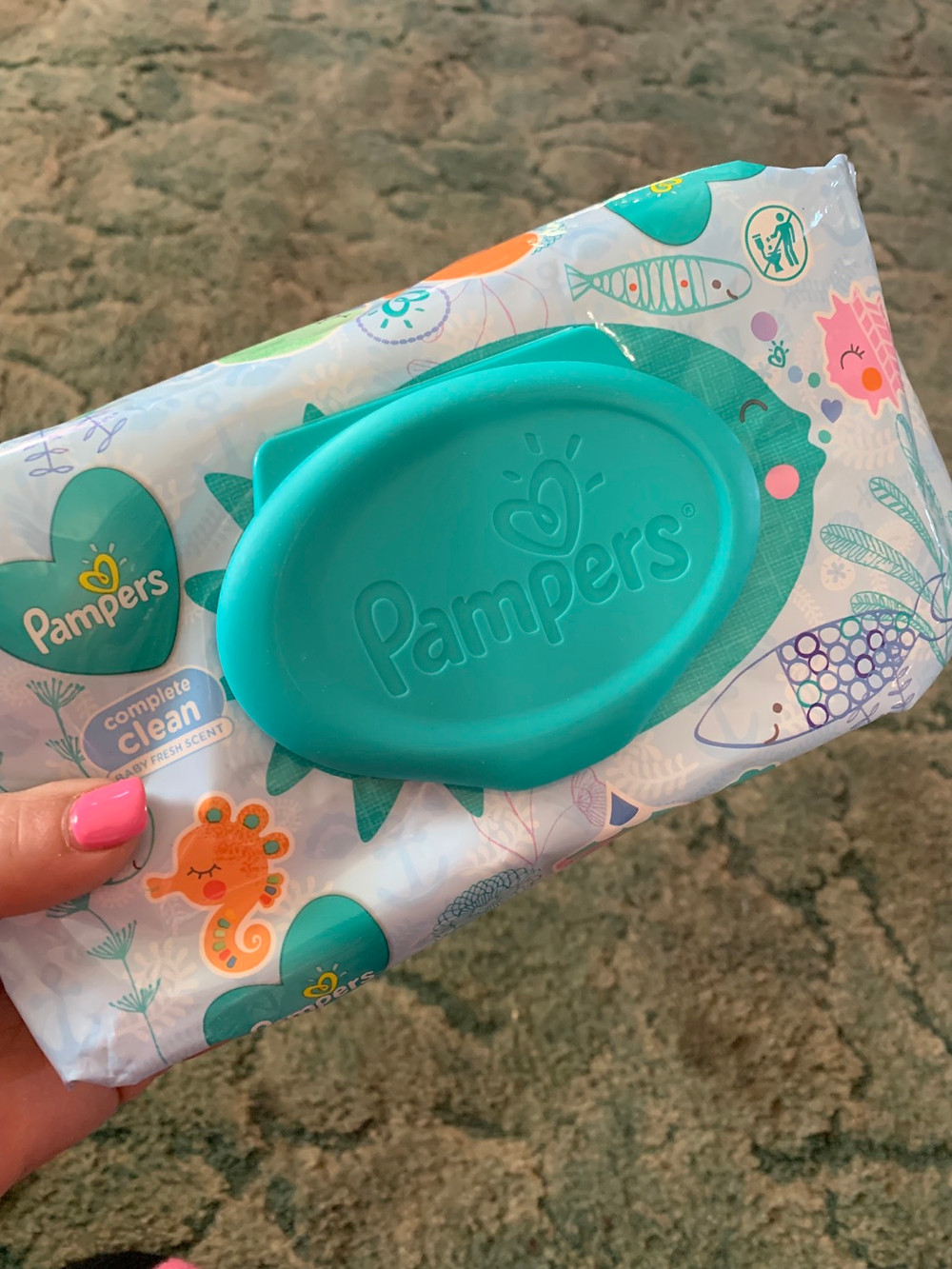 lady holding a pack of of pampers wipes
