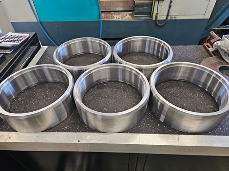 Five metal rings arranged on a table, background of workshop.