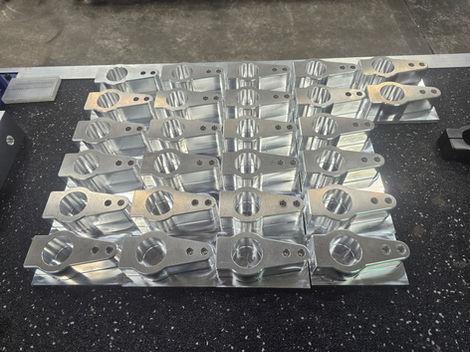 Array of machined metal parts, Engineering Cnc Mach on a work surface.