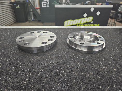 Two metal components display on a bumpy surface with Thorpe Engineering text