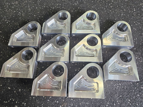 Ten machined metal parts arranged on a surface, Engineering Cnc Mach.
