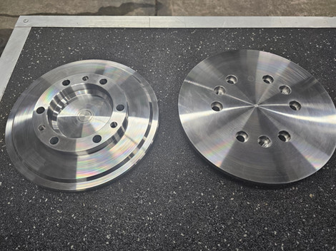 Two metal components displayed on a surface featuring engineering cnc mach.