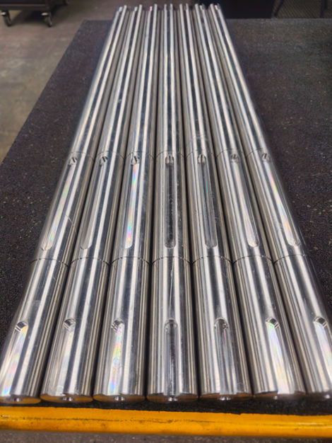 Group of metal drive shafts, arranged neatly, ready for use.