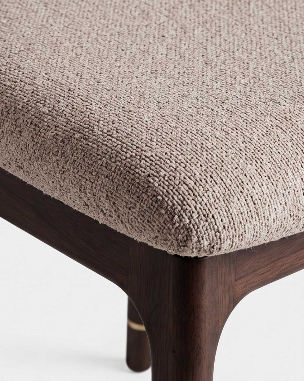 Close-up of a chair with textured beige fabric seat.