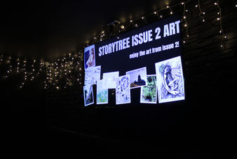 Photo of StoryTree Issue 2 Art on display on the TVs at The Bungalow.