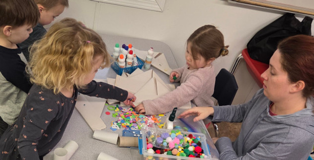 Parent and children enjoying a preschool activity together.