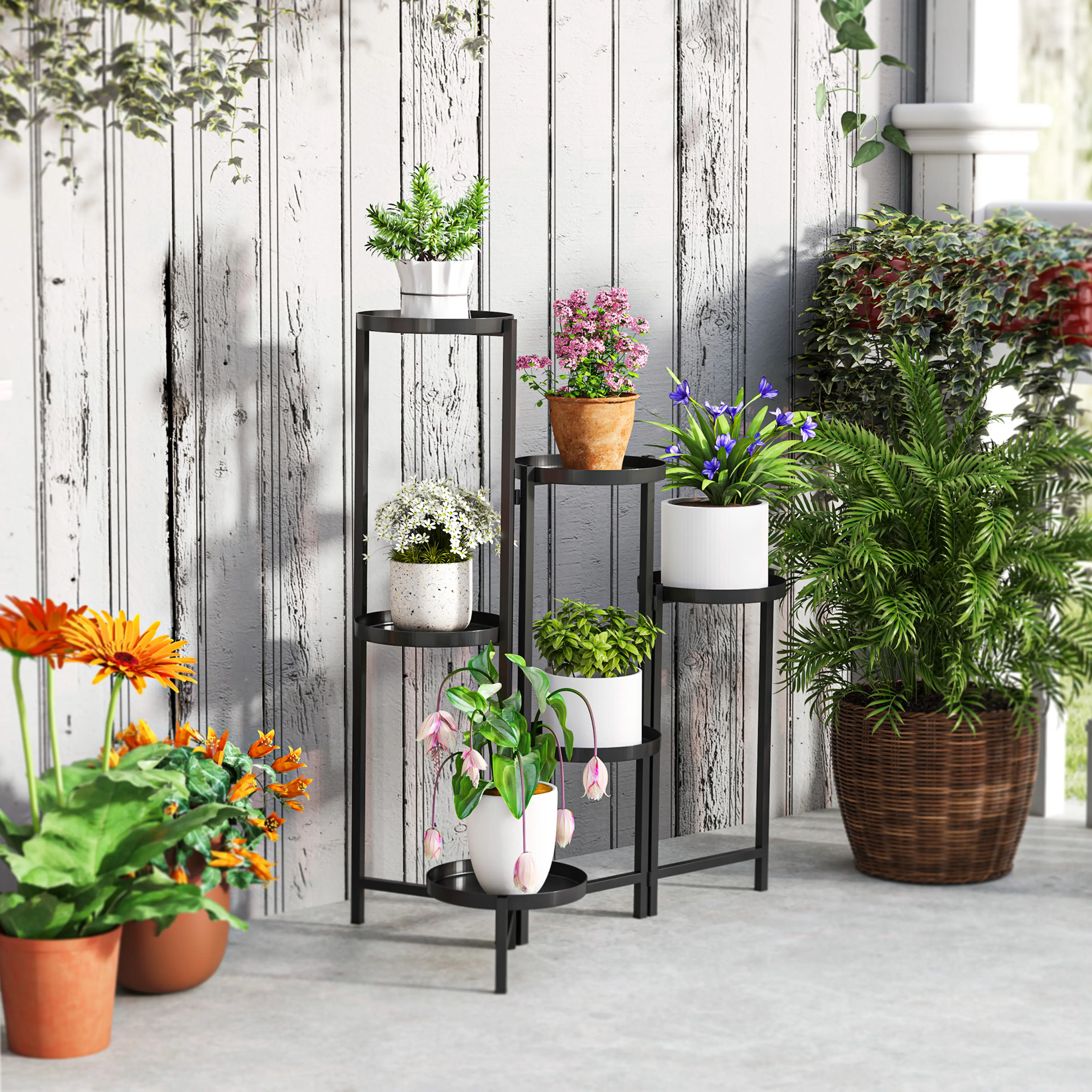 Blomstället med blommor på en uteplats vid ett staket