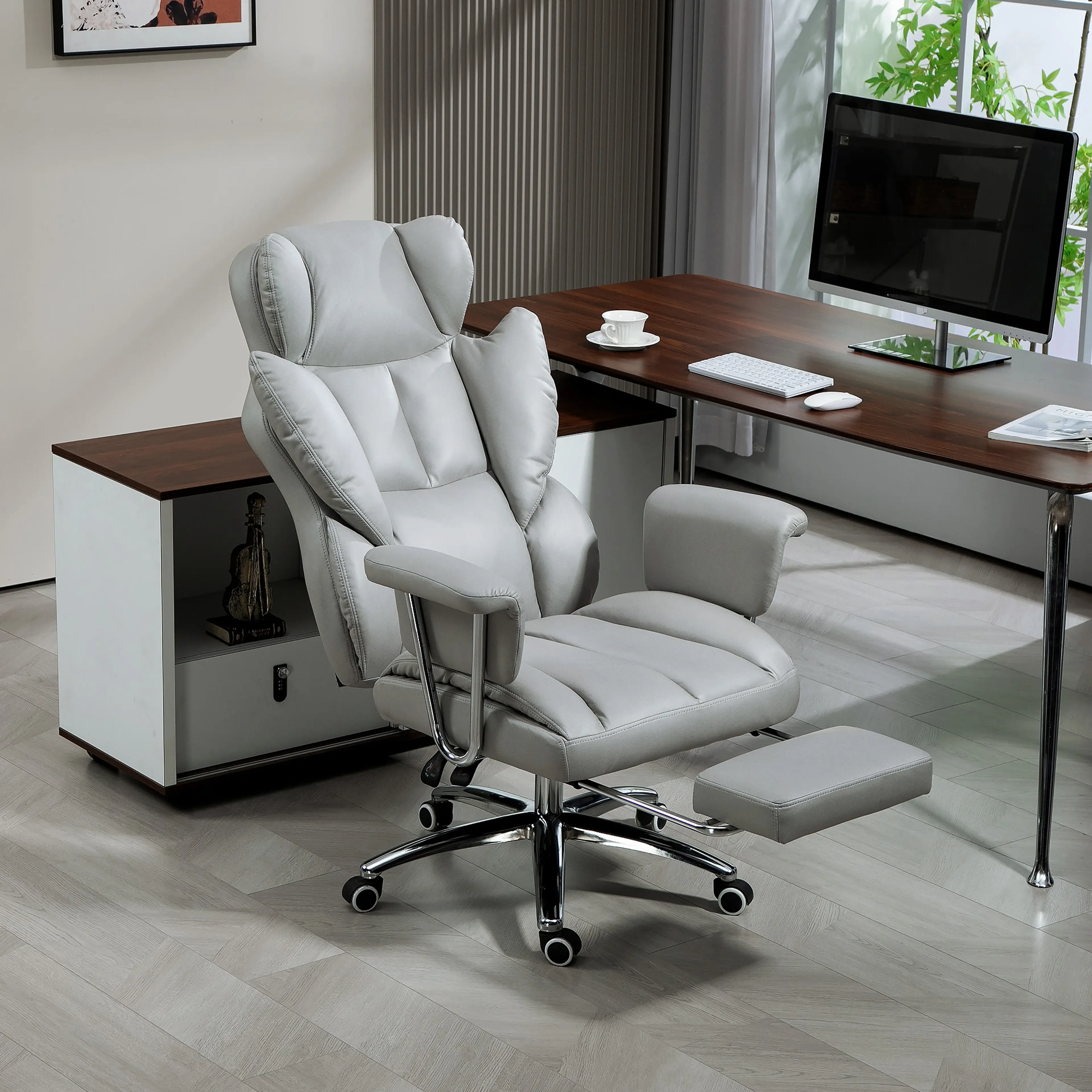Chefsstol i ljusgrå mikrofibertyg med fotstöd, vid ett skrivbord med skärm och hurts