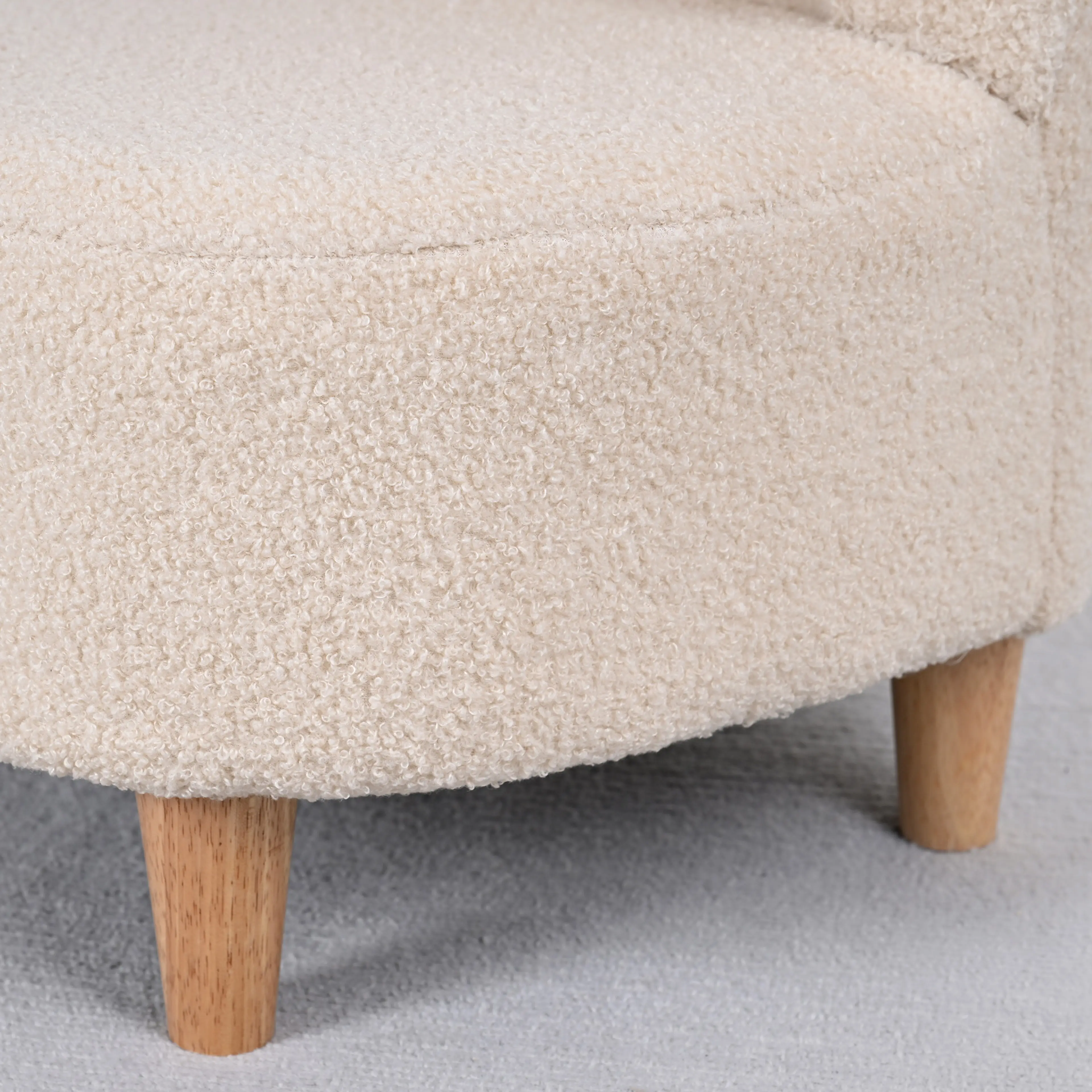 Närbild på barnfåtöljens teddyfleece och det svarvade träbenet
