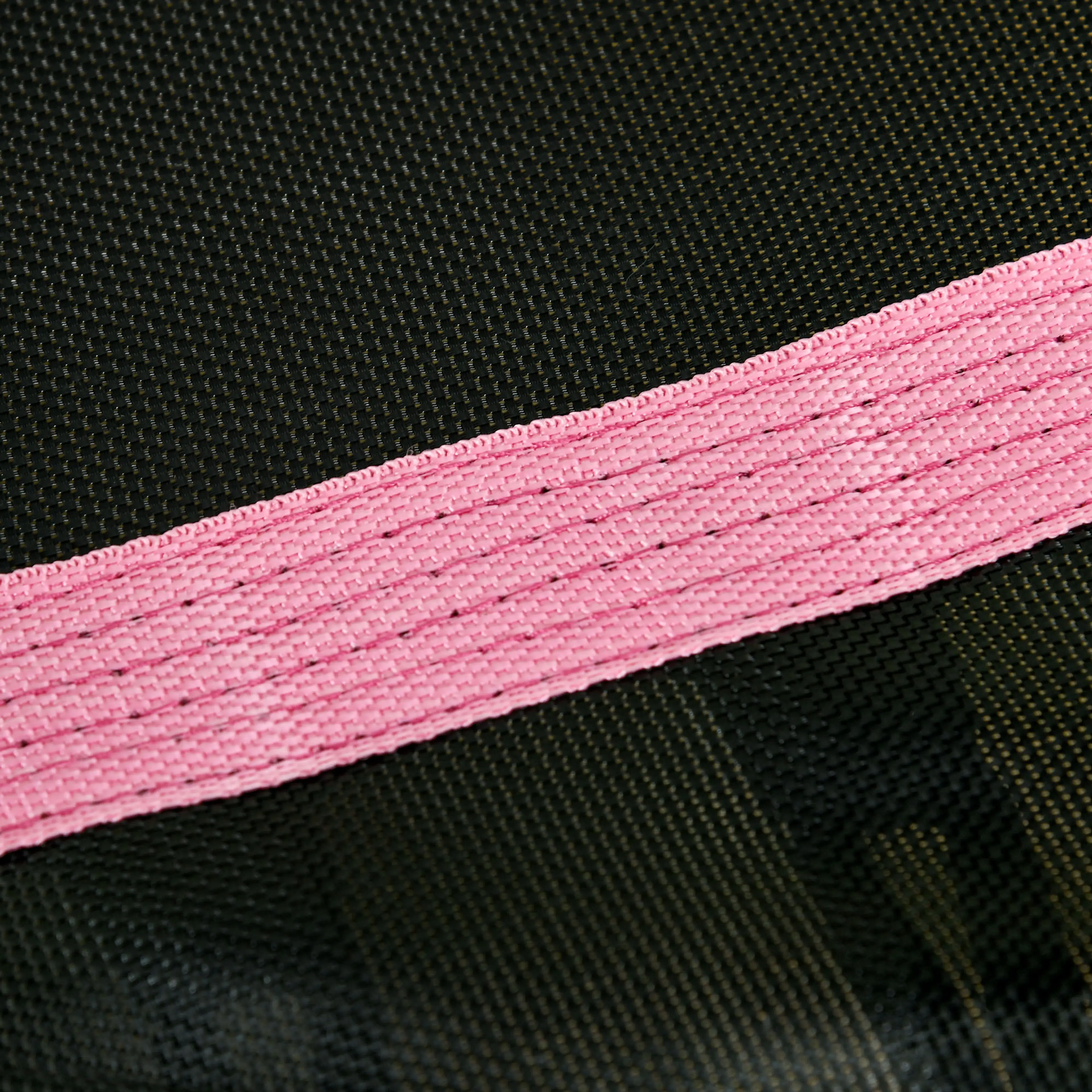 Närbild på det rosa kantbandet mot den svarta hoppmattan