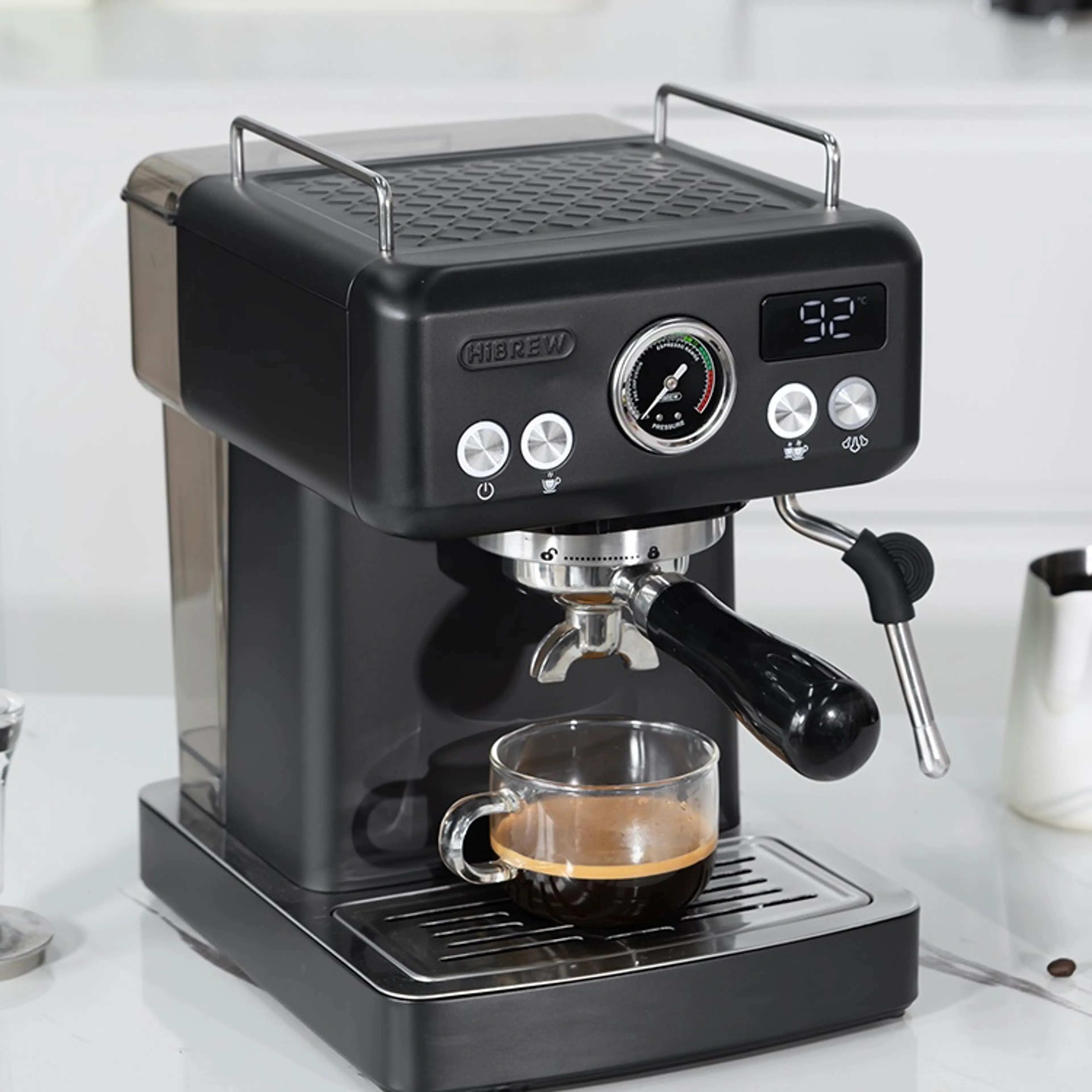 Espressomaskin HiBREW H10A på en marmorbänk med en espresso i glaskopp under bäraren