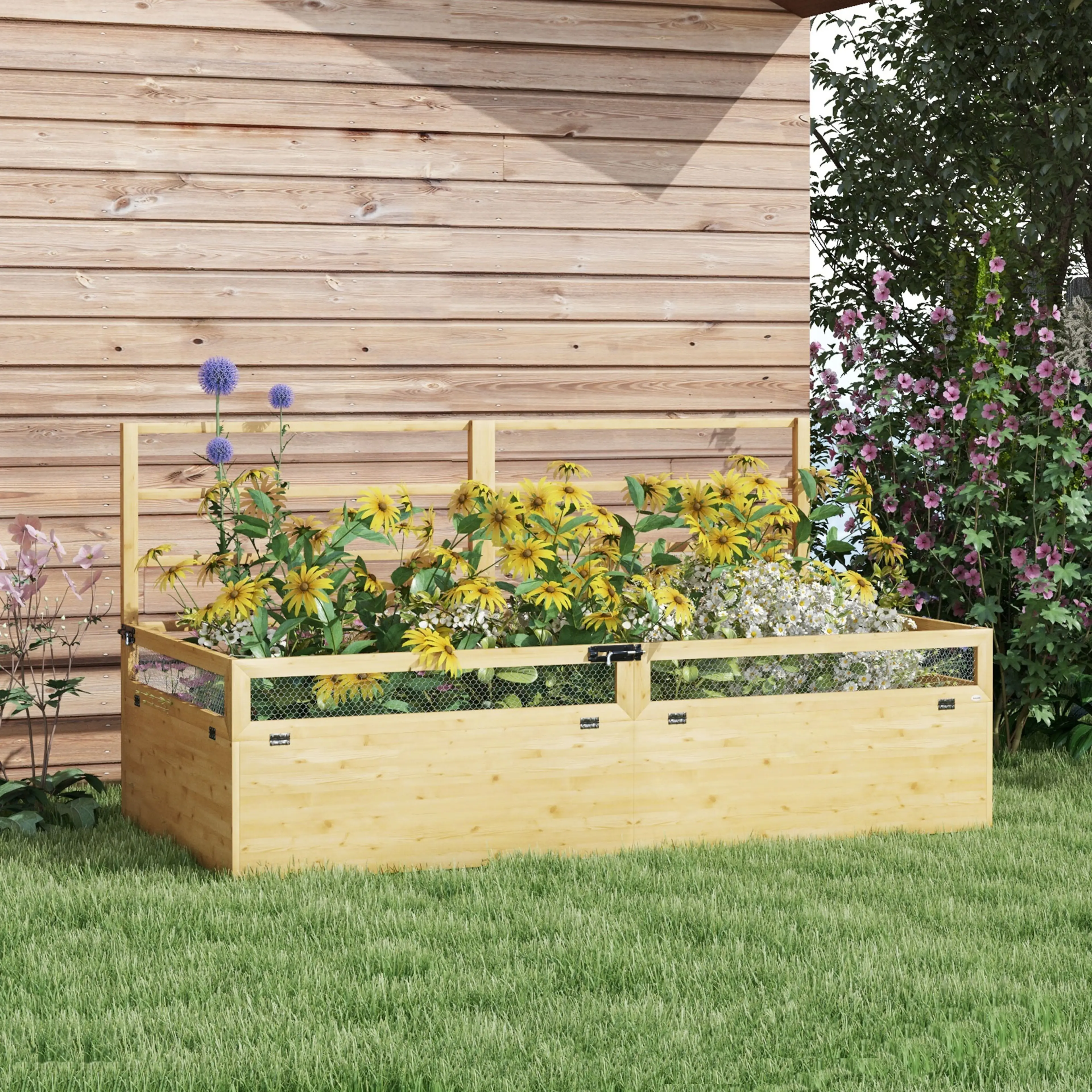 Odlingslådan i en trädgård framför ett brunt trästaket, planterad med gula och blå blommor