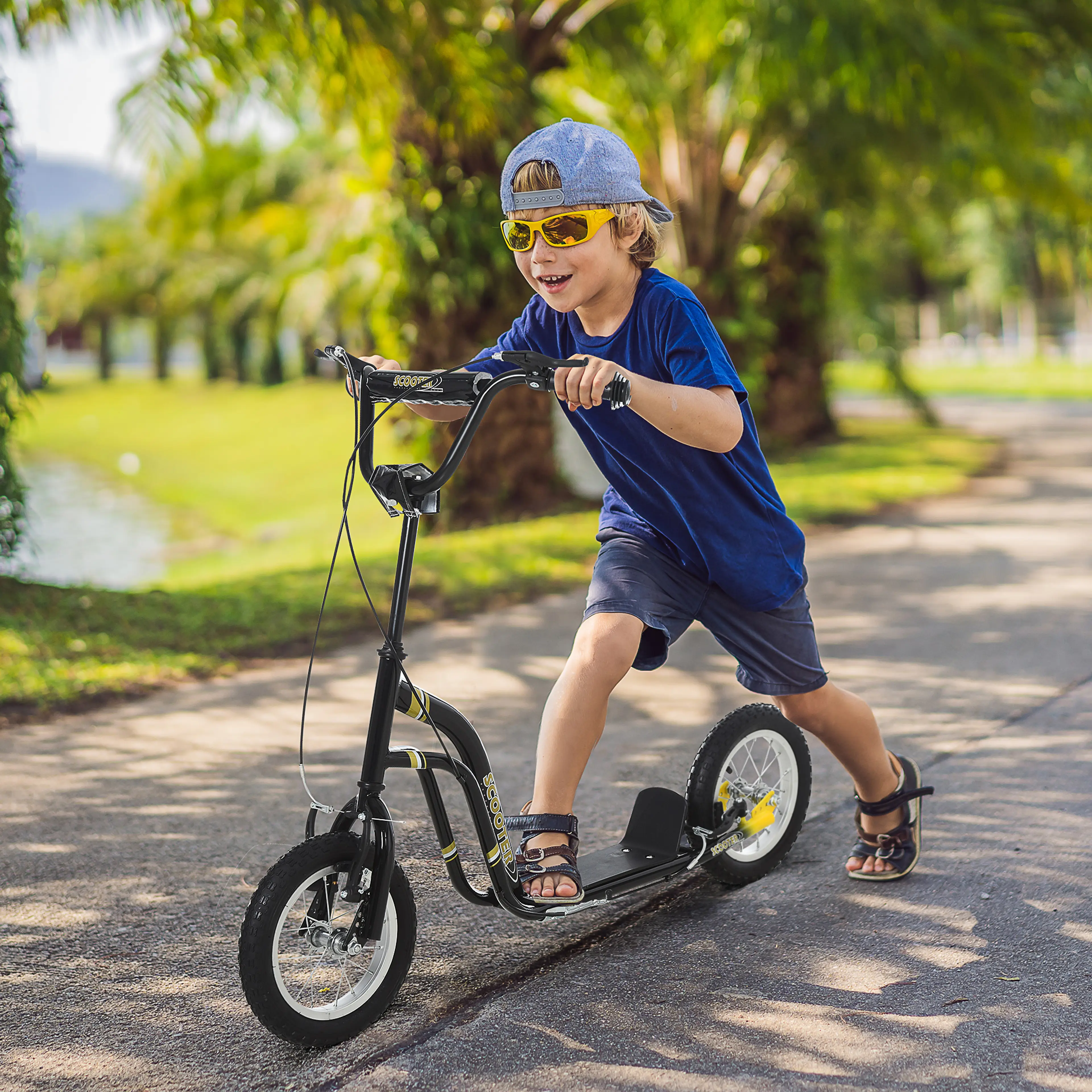Pojke sparkar fram på den svarta sparkcykeln på en gångväg i en park